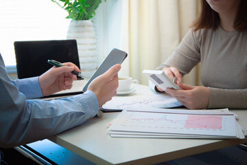 Young businessmen, a girl and a guy, work in the office on drawing up an annual report. Hands close-up.