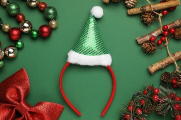 Stylish party headband and Christmas decor on green background, flat lay