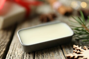Natural solid perfume in container and Christmas decor on wooden table, closeup