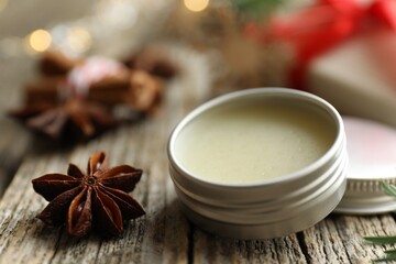 Natural solid perfume in container and anise star on wooden table, closeup