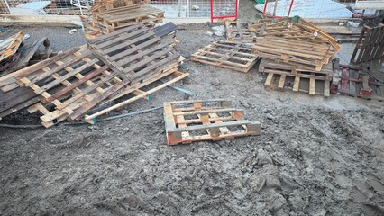 Discarded Wooden Pallets on Muddy Ground
