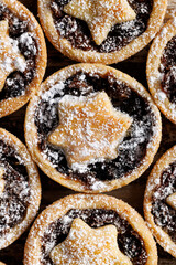 Close-up view of the Christmas cookies sprinkled with icing sugar. Traditional british Christmas dessert, mince pies