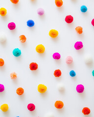 Colorful pom poms texture isolated on white background