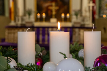 Advent Wreath in a Church. White Candles and Purple Ornaments on an Advent Wreath.
