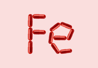 Creative idea for iron anemia concept. Supplement of ferritin in red capsule. Capsule representing iron supplementation for treating or managing iron deficiency and anemia.