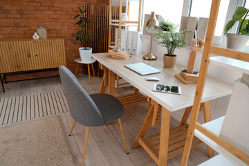 Interior of modern office with workplace, shelf units and window