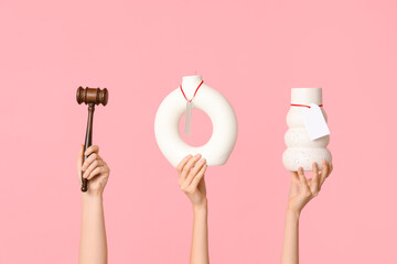 Female hands with auction gavel and antique vases on pink background