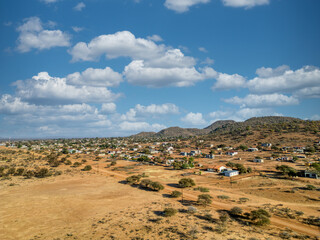 aerial view african village southern Africa, mountain range and hills, acacia trees and bush , sunny late afternoon