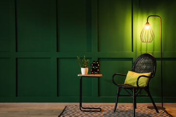 Interior of dark room with glowing lamps, chair and table at night