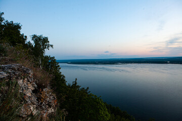 Soft hues of twilight grace the Vilga River as daylight fades, reflecting calmness and the beauty of nature.