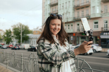 Vlogger traveler woman recording video on phone camera share via app her travel vacation in the city. Gen Z Plus size girl influencer shooting social media stories on the street