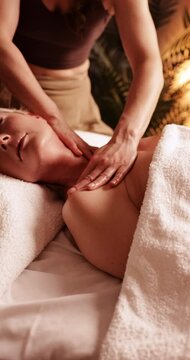Mature woman during a skin rejuvenating massage at spa - vertical video