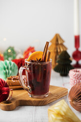 Warm mulled wine with cinnamon, orange, and star anise on a Christmas background