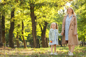 Fototapeta premium Happy mother with her little daughter walking in park on autumn day