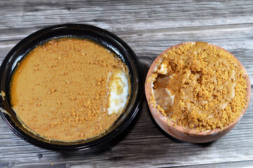 An image of Biscuits butter spread and pieces topping on rice pudding also called Riz au lait, Sütlaç, Sholezard and moghli, and also on Egyptian bread pudding Om Ali made of Egyptian bread roqaq