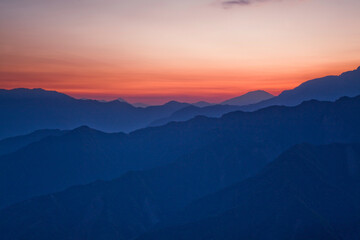 Sunrise view of magnificent layered mountains and colorful clouds background in Taiwan.