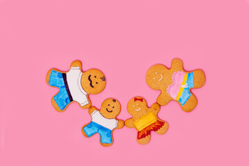 Top view of a family of gingerbread men on a pink background. Ginger cookies. Food concept. Family Day.