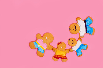 Top view of a family of gingerbread men on a pink background. Ginger cookies. Food concept. Family Day.