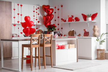 Stylish interior of light kitchen decorated for Valentine's Day with beautiful roses and wine on table