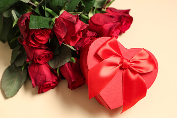 Heart-shaped gift box and beautiful rose flowers on color background. Valentine's Day celebration