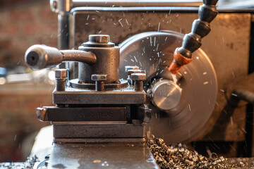 Close-up of a lathe cutting brass shaft parts and shavings. Metalworking process on a lathe.