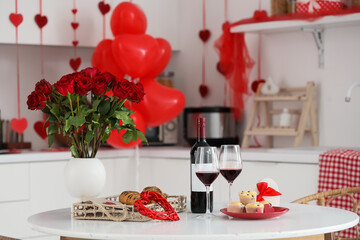 Red wine with pastry and roses on dining table in kitchen decorated for Valentine's Day