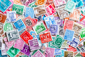 Philately.Postage stamps.Collection of stamps and magnifying glass.A collection of world stamps in a pile.Postage stamps from different countries and times