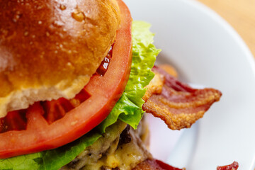 Close-Up of a Delicious Bacon Cheeseburger with Fresh Tomato and Lettuce