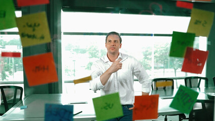 Portrait of professional businessman analysis marketing idea on sticky notes. Smiling caucasian...