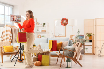 Beautiful young woman in autumn clothes with shopping bags and laptop at home. Online shopping concept