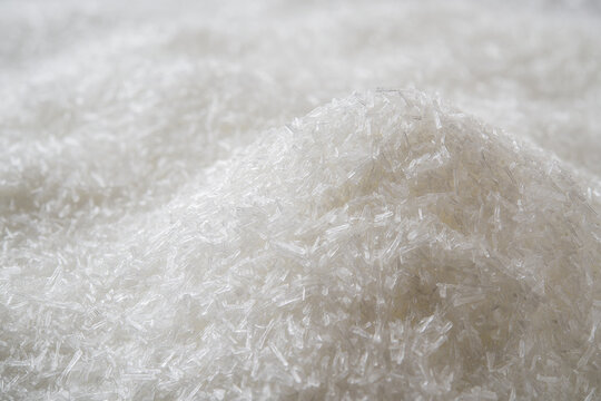 Heap of monosodium glutamate white crystals background. Pile of food additive MSG macro close-up. Concept of flavor enhancer E621 food ingredient.