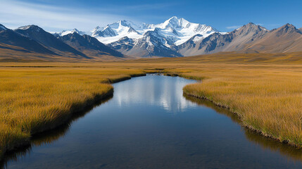 Fototapeta premium Landscape background serene alpine valley with clear stream reflecting snow capped mountains, surrounded by golden grasslands. tranquil landscape evokes sense of peace and natural beauty