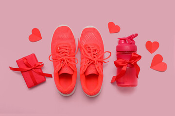 Composition with stylish sports shoes, bottle of water, gift and hearts on pink background. Valentine's Day celebration