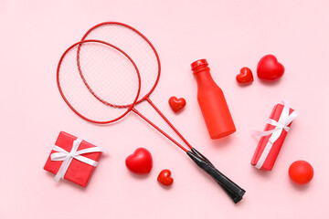 Composition with badminton rackets, gifts and red hearts on pink background. Valentine's Day celebration