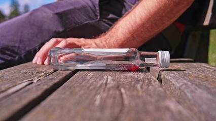 Empty Strong Alcohol Drink Mini NIp Bottle Left on Sidewalk Bench by Drunk Addicted Man