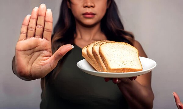 Concept: No-carb diet, excess weight, calories. Woman on a diet, making a gesture with her palm to white bread. Slices of white bread on plates.