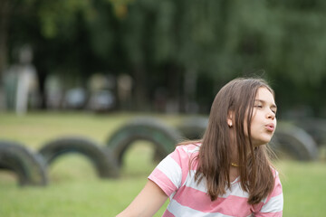 A young beautiful girl frolics in a summer park.