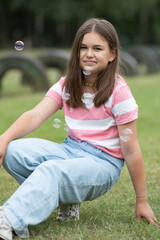 A young beautiful girl frolics in a summer park.