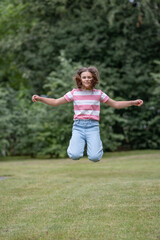 A young beautiful girl frolics in a summer park.