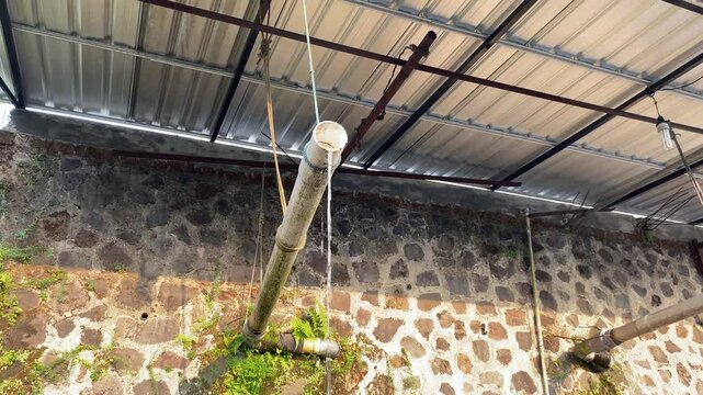 Water flow from plastic white pipe, under roof top