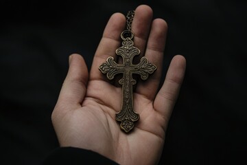Catholic Cross in Male Hand with Black Background
