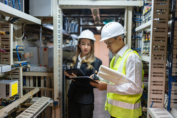 Asian male and female engineers excel in designing electrical circuits for power plants, driving...