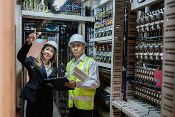 The world depends on Asian male and female engineers to develop efficient electrical circuits in power plants, ensuring the energy industry meets global energy demands effectively.