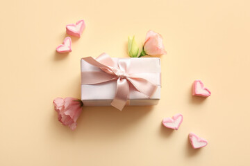 Composition with gift box, heart-shaped marshmallows and flowers on color background. Valentine's Day celebration