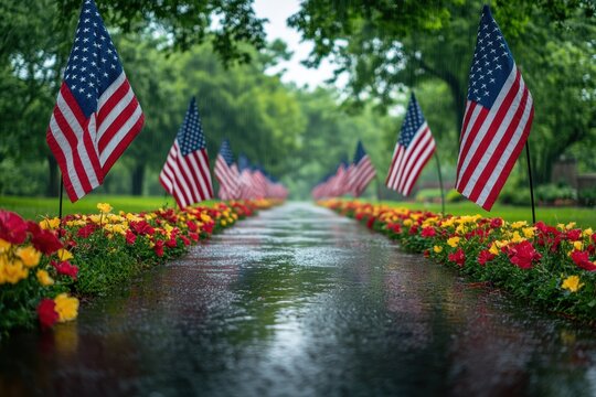 A beautifully decorated path with American flags and vibrant flowers, reflecting national pride and unity on a calm rainy day in a lush green park setting.