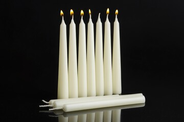 Six Lit Candles and Three Unlit Candles on Black