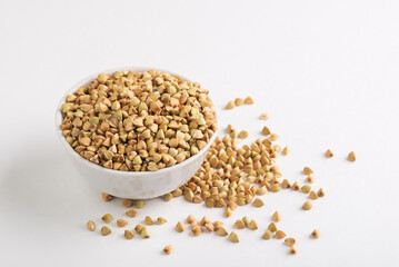 Dietary green buckwheat groats in a  white  bowl isolated on white background