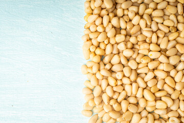 Pine nuts on blue, wooden background. Space for text. Copyspace.