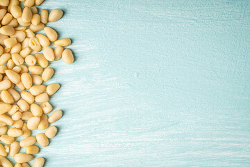 Pine nuts on blue, wooden background. Space for text. Copyspace.