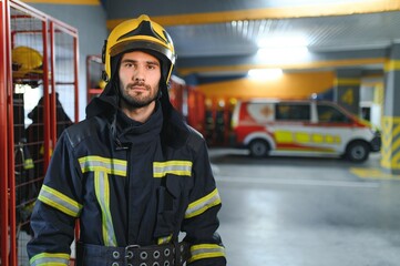 Obraz premium Young handsome fireman in the fire department